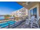 Spacious balcony showcasing pool and waterfront views, complemented by cozy outdoor seating at 7902 Sailboat Key S Blvd # 206, South Pasadena, FL 33707