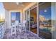 Charming outdoor balcony features white Adirondack chairs, a table, and slider door entry at 7902 Sailboat Key S Blvd # 206, South Pasadena, FL 33707