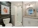Bathroom showcases a wood accent wall, seashell decor, and a frameless glass shower at 7902 Sailboat Key S Blvd # 206, South Pasadena, FL 33707