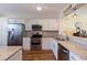 Modern kitchen featuring white cabinets, granite countertops, stainless steel appliances, and wood floors at 7902 Sailboat Key S Blvd # 206, South Pasadena, FL 33707