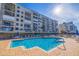 Inviting outdoor pool with lounge chairs and umbrellas at the complex near the bay at 7902 Sailboat Key S Blvd # 206, South Pasadena, FL 33707