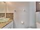 Bathroom featuring a modern glass bowl sink, granite countertop, and mosaic backsplash, combining style and functionality at 814 15Th Ne St, Ruskin, FL 33570