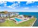 Beautiful pool with a view of the bay in this sunny aerial view of community property at 9 Forbes Pl # 206, Dunedin, FL 34698