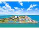 Aerial view of waterfront condo community with recreational amenities, pool, tennis court, and beach at 9 Forbes Pl # 206, Dunedin, FL 34698