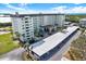 Exterior view of a multi-story condo building showing a convenient covered parking area and beautifully maintained grounds at 9 Forbes Pl # 206, Dunedin, FL 34698