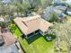 Expansive home with a well-manicured lawn and a screened-in patio surrounded by mature trees at 15944 Ternglade Dr, Lithia, FL 33547