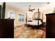 Spacious bedroom with a four-poster bed, wood floors, plantation shutters and a ceiling fan at 15944 Ternglade Dr, Lithia, FL 33547