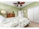 Green bedroom featuring bed, closet, dresser and ceiling fan at 15944 Ternglade Dr, Lithia, FL 33547