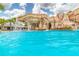 Tropical community pool with a decorative rock waterfall feature and palm trees at 15944 Ternglade Dr, Lithia, FL 33547
