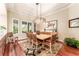 Bright dining room features modern chandelier, hardwood floors, and large windows with shutters at 15944 Ternglade Dr, Lithia, FL 33547
