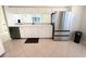 Kitchen featuring stainless steel refrigerator, white cabinets, countertops, tiled flooring and black dishwasher at 1609 Shady Oaks Dr, Oldsmar, FL 34677