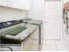 Laundry room with modern washer and dryer, tile flooring, and a door at 1609 Shady Oaks Dr, Oldsmar, FL 34677