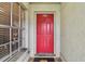 Eye-catching red front door and textured wall are seen in this porch view at 1630 Spinning Wheel, Lutz, FL 33559