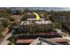 Aerial view of a multi-unit residential building surrounded by trees and water in the distance at 2612 Pearce Dr # 310, Clearwater, FL 33764