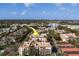 An aerial view of a condo complex featuring mature trees and convenient parking, with city views in the distance at 2612 Pearce Dr # 310, Clearwater, FL 33764