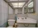 A full bathroom with tub, toilet, vanity with white sink and large framed mirror at 2612 Pearce Dr # 310, Clearwater, FL 33764
