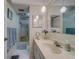 Bright bathroom featuring a vanity with ample counter space, pendant lighting, a shower, and blue towels at 2612 Pearce Dr # 310, Clearwater, FL 33764