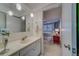 Well-lit bathroom with a vanity, pendant lighting, mirror, and an adjacent bedroom at 2612 Pearce Dr # 310, Clearwater, FL 33764