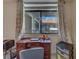 The room has an ornate desk, a chair and a lamp with natural light coming in from a window with white trim at 2612 Pearce Dr # 310, Clearwater, FL 33764