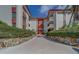 Beautiful condo building with white walls, red trim, nicely manicured hedges, and a walkway leading to a red front door at 2612 Pearce Dr # 310, Clearwater, FL 33764
