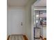 Hallway with white door, hardwood floors, gray rug, and view of the exterior through a window with sheer curtains at 2612 Pearce Dr # 310, Clearwater, FL 33764