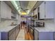 Kitchen featuring stainless steel appliances, white cabinets, gray countertops, and view of the dining and living area at 2612 Pearce Dr # 310, Clearwater, FL 33764