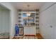 Kitchenette with white cabinets, stainless steel trash can, wood floors, and gray and white striped curtains at 2612 Pearce Dr # 310, Clearwater, FL 33764