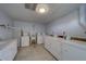 Bright laundry room provides multiple machines, tile flooring, white cabinets and countertop for folding and organizing at 2612 Pearce Dr # 310, Clearwater, FL 33764