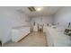 Bright laundry room provides multiple machines, tile flooring, white cabinets and countertop for folding and organizing at 2612 Pearce Dr # 310, Clearwater, FL 33764