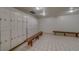 Clean locker room featuring rows of white lockers and wooden benches at 2612 Pearce Dr # 310, Clearwater, FL 33764