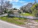 Wide shot of a home surrounded by mature trees and a white picket fence at 309 11Th Sw St, Ruskin, FL 33570