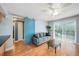 Cozy living room showcasing a blue sliding barn door, comfortable sofa, and sliding glass doors at 3711 W Iowa Ave # 214, Tampa, FL 33611