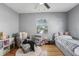 A bedroom with hardwood floors, a ceiling fan, two windows, stuffed animals and a light gray chair at 4537 22Nd N St, St Petersburg, FL 33714