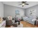 A bedroom with hardwood floors, a ceiling fan, two windows, stuffed animals and a light gray chair at 4537 22Nd N St, St Petersburg, FL 33714