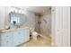 Updated bathroom features granite countertop, walk-in shower with a built-in seat, and linen closet at 7910 Sun Island S Dr # 305, South Pasadena, FL 33707