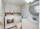 This features a modern washer and dryer, accompanied by ample storage cabinets and a pristine white sink at 7910 Sun Island S Dr # 305, South Pasadena, FL 33707