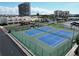 Scenic aerial view of the community tennis courts, palm trees, and nearby condo buildings on a sunny day at 7910 Sun Island S Dr # 305, South Pasadena, FL 33707
