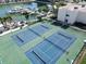 Aerial shot showcases two tennis courts next to a marina filled with various boats at 7910 Sun Island S Dr # 305, South Pasadena, FL 33707