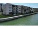 Multi-story condo building along a waterfront with boat docks and lush landscaping at 7910 Sun Island S Dr # 305, South Pasadena, FL 33707