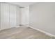 Neutral bedroom showcasing vinyl plank flooring, white closet doors, and a doorway leading to other rooms at 8408 Bob Wiggs Ave, Lithia, FL 33547