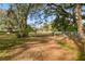 Leafy driveway leading to the property, framed by trees and fencing at 8408 Bob Wiggs Ave, Lithia, FL 33547