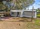 Exterior view of home with a metal roof, shaded yard and natural surroundings on a sunny day at 8408 Bob Wiggs Ave, Lithia, FL 33547