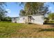 Charming single-story home with gray siding, wooden ramp and stairs, with a large grassy front yard at 8408 Bob Wiggs Ave, Lithia, FL 33547