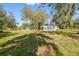 Exterior view of a home with a large grassy yard and surrounding mature trees at 8408 Bob Wiggs Ave, Lithia, FL 33547
