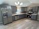 Bright kitchen featuring stainless steel appliances, gray cabinets, and tile backsplash at 8408 Bob Wiggs Ave, Lithia, FL 33547