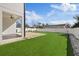 A modern backyard features artifical grass and a privacy fence at 902 W Sligh Ave, Tampa, FL 33604