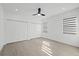 Bedroom featuring double closets, wood-look flooring, black ceiling fan, and modern shades at 902 W Sligh Ave, Tampa, FL 33604