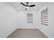 Empty bedroom featuring hardwood floors, a black ceiling fan, and windows with modern shades at 902 W Sligh Ave, Tampa, FL 33604