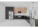 Modern kitchen features stainless steel appliances, marble countertops, and sleek black and wood cabinetry at 902 W Sligh Ave, Tampa, FL 33604