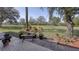 Back patio featuring brick pavers, a bench, and picturesque views of the manicured lawn at 1290 Clays Trl, Oldsmar, FL 34677